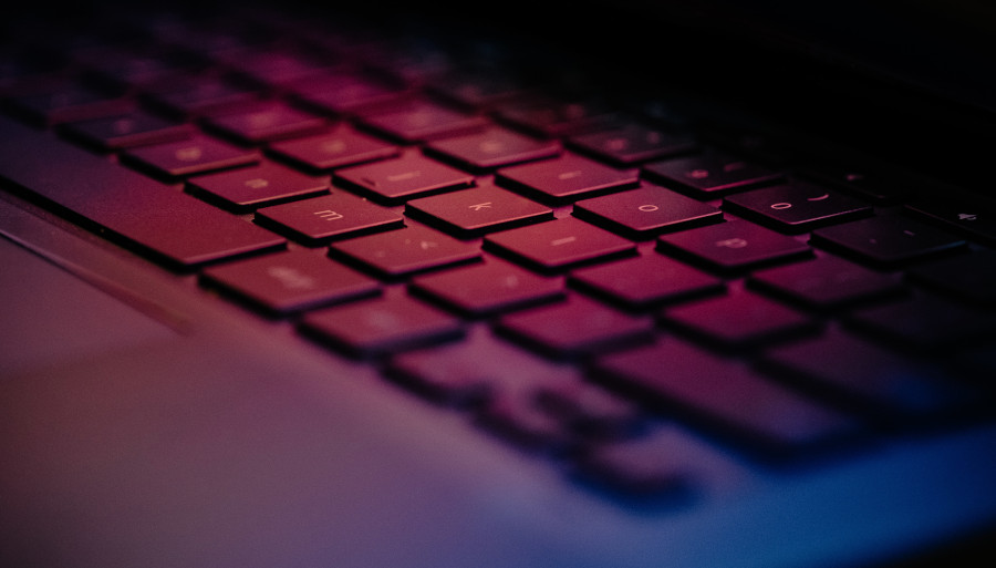 teclado de laptop iluminado por colores azul y violeta